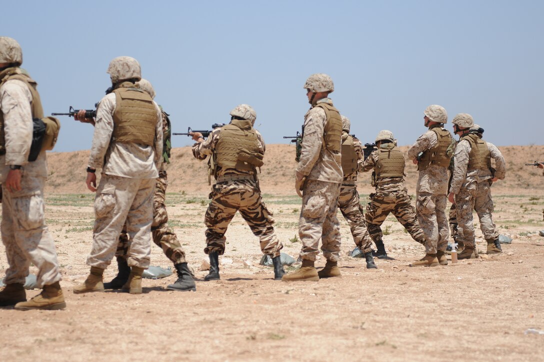 Marines from Military Police Company, Headquarters Battalion, 4th Marine Division, coach Moroccan soldiers as they fire M-4 carbines here May 21 during the host-nation weapons training portion of exercise African Lion 2011. African Lion is an annually scheduled, bilateral U.S.-Moroccan exercise designed to promote interoperability and mutual understanding of each nation’s military tactics, techniques and procedures.::r::::n::